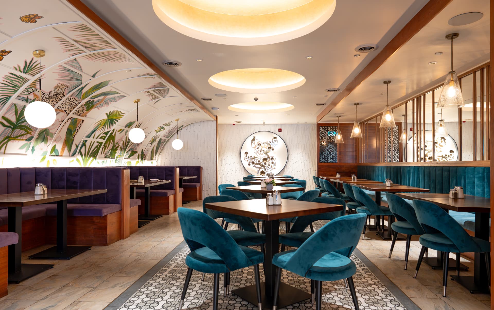 SOLENA dining room with jaguar palm mural, violet booths, teal velvet chairs and glowing halo ceiling lights