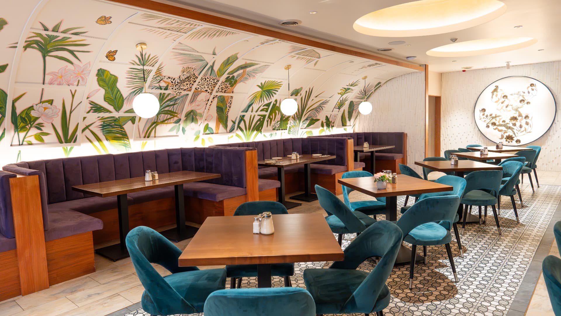 SOLENA dining room with hand-painted tropical mural, violet banquettes and teal velvet chairs